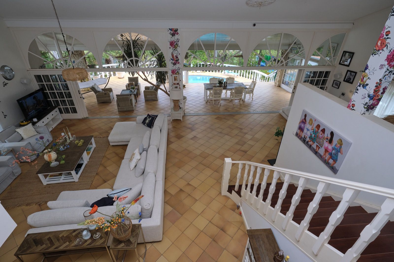 Open leefruimte met boogvensters en uitzicht op zwembad